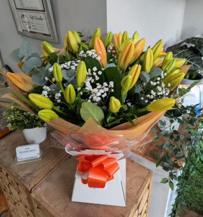 Apricot Lily Bouquet - A striking hand-tied bouquet showcasing elegant lilies with fresh foliage and delicate accents, beautifully wrapped to create a timeless and thoughtful gift.