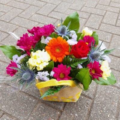 Florist Choice Gift Bag - A cheerful basket arrangement in vibrant seasonal shades, handcrafted by a local florist to brighten any occasion with fresh, colourful blooms.
